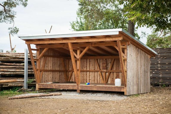 Eine halboffene Schutzhütte aus Holz mit Blechdach