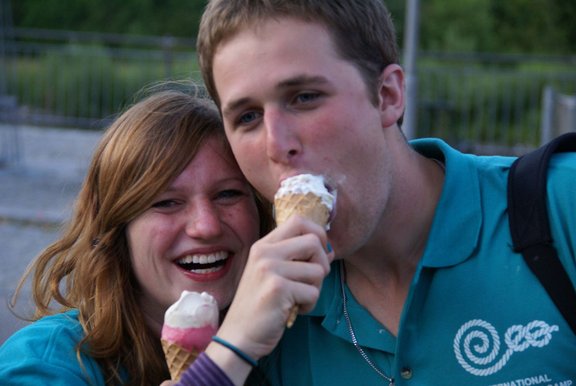 Ein Mann und eine Frau essen lachend gemeinsam Eis